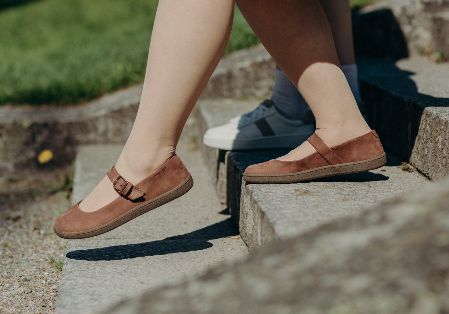 Two people walking down stairs wearing BREJD shoes.